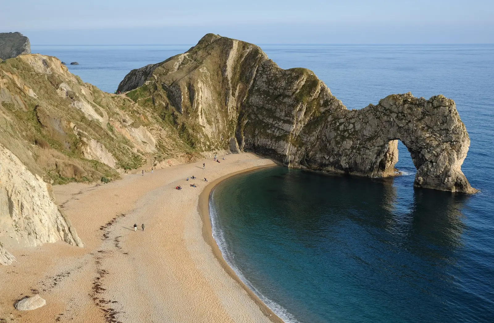 Durdle Door’s limestone arch over a curving beach on the Jurassic Coast