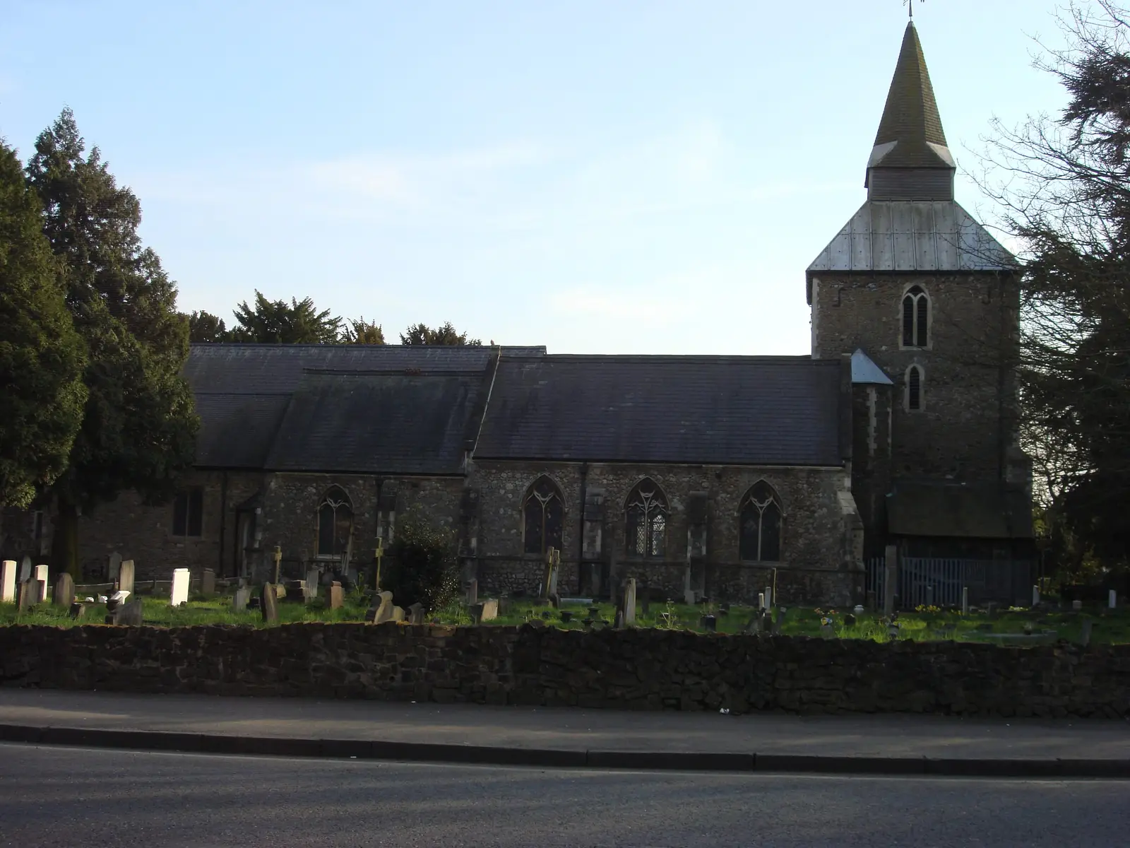 St Laurence Church in Upminster behind its churchyard