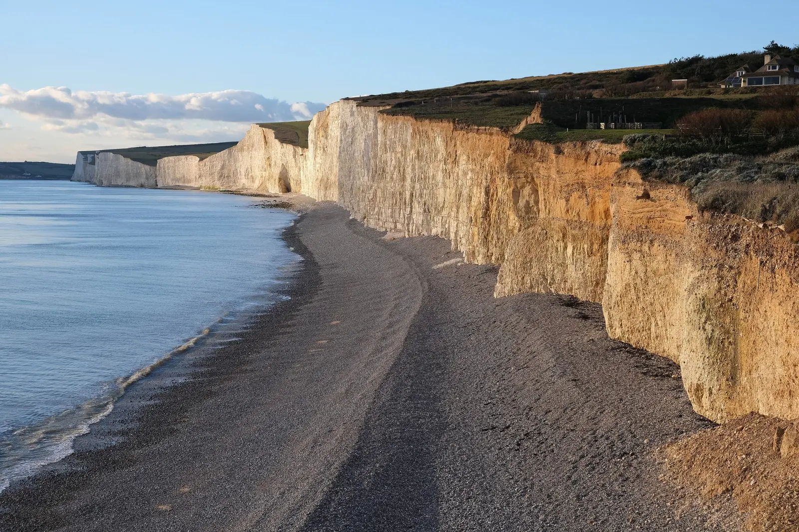 The white chalk cliffs of the Seven Sisters above a shingle beach