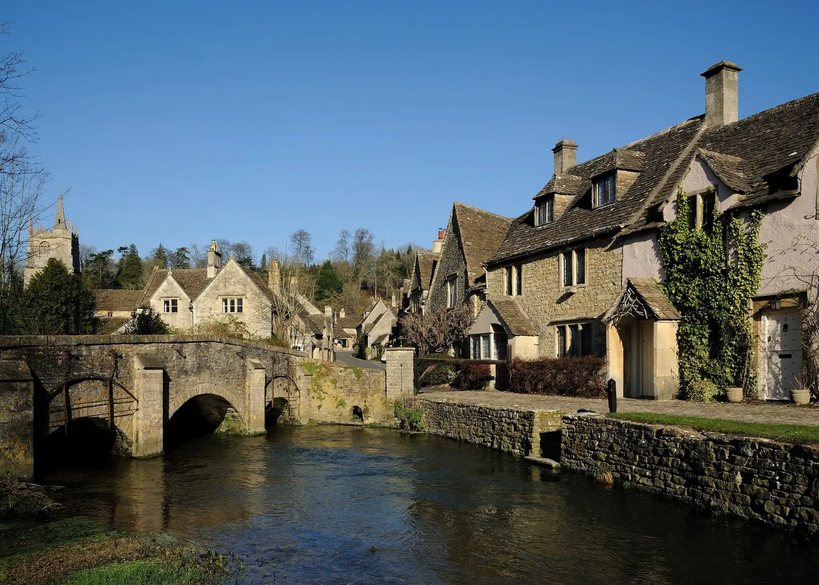Honey-stone cottages and a bridge over the river at Castle Combe