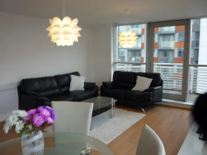 Two leather sofas around a glass coffee table, with a balcony behind